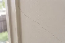 Hairline crack running through painted plaster wall in an Australian home