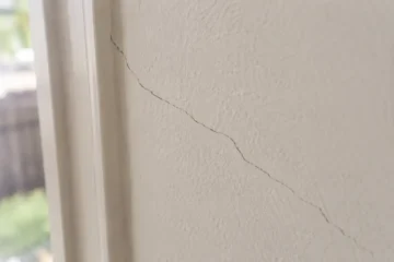 Hairline crack running through painted plaster wall in an Australian home