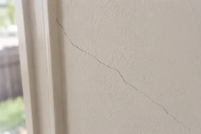 Hairline crack running through painted plaster wall in an Australian home